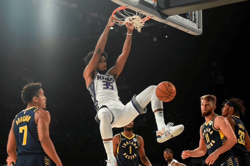 Sacramento Kings player Marvin Bagley (C) shoots a ball as Indiana Pacers players Domantas Sabonis (2nd R) and Malcolm Brogdon (L) look on during the first pre-season NBA basketball game between Sacramento Kings and Indiana Pacers at the NSCI Dome in Mumbai on October 4, 2019.