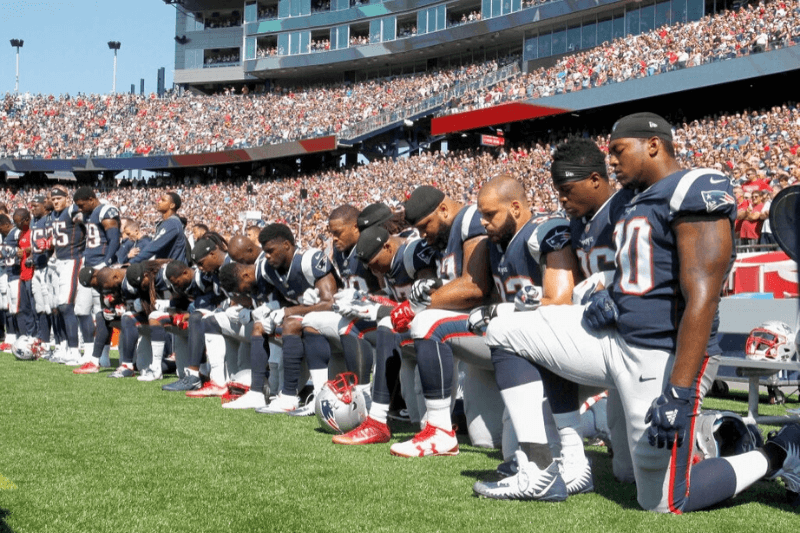 FOXBORO, MA - SEPTEMBER 24: Members of the New England Patriots kneel during the National Anthem before a game against the Houston Texans at Gillette Stadium on September 24, 2017 in Foxboro, Massachusetts.