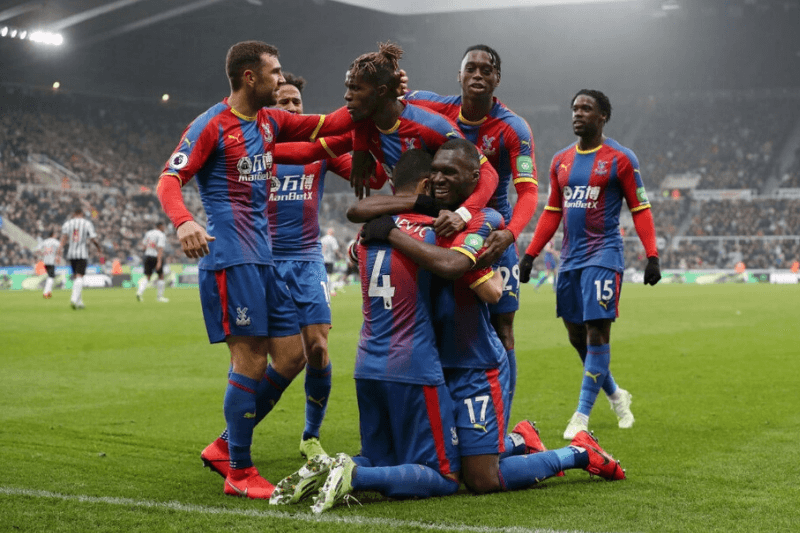 NEWCASTLE UPON TYNE, ENGLAND - APRIL 06: Luka Milivojevic of Crystal Palace celebrates after scoring his team's first goal from the penalty spot wit his team mates during the Premier League match between Newcastle United and Crystal Palace at St. James Park on April 06, 2019 in Newcastle upon Tyne, United Kingdom.