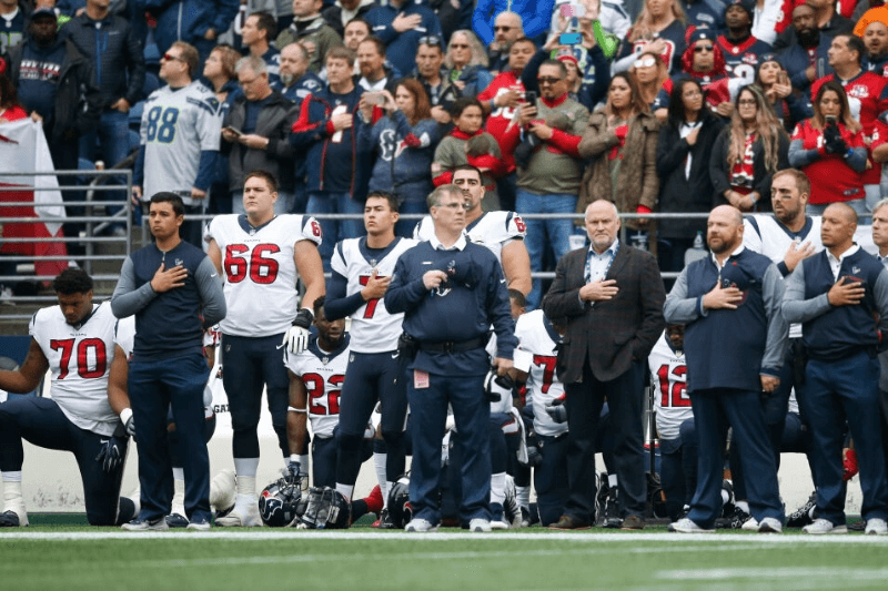 SEATTLE, WA - OCTOBER 29: Members of the Houston Texans stand and kneel before the game against the Seattle Seahawks at CenturyLink Field on October 29, 2017 in Seattle, Washington. During a meeting of NFL owners earlier in October, Houston Texans owner Bob McNair said "we can't have the inmates running the prison", referring to player demonstrations during the national anthem.