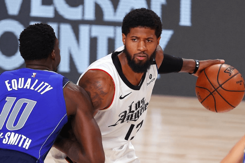 Aug 21, 2020; Lake Buena Vista, Florida, USA; Paul George #13 of the LA Clippers looks to pass against Dorian Finney-Smith #10 of the Dallas Mavericks during the second half in a NBA basketball first round playoff game at AdventHealth Arena.