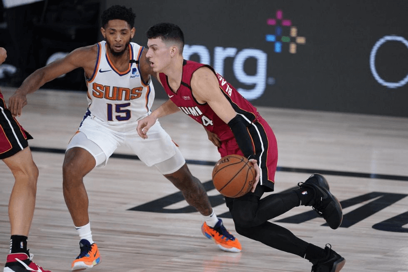 Aug 8, 2020; Lake Buena Vista, Florida, USA; Miami Heat's Tyler Herro (14) is defended by Phoenix Suns' Cameron Payne (15) during the second half of an NBA basketball game at Visa Athletic Center.
