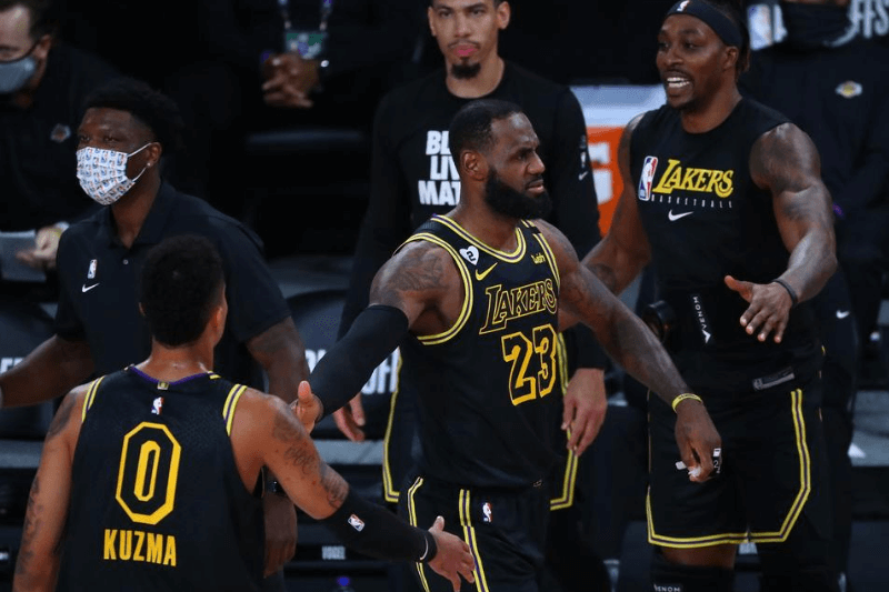 Aug 24, 2020; Lake Buena Vista, Florida, USA; Los Angeles Lakers forward LeBron James (23) reacts with Los Angeles Lakers forward Kyle Kuzma (0) in the first half against the Portland Trail Blazers in game four of the first round of the 2020 NBA Playoffs at AdventHealth Arena.
