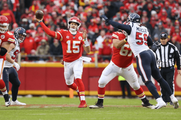 KANSAS CITY, MO - JANUARY 12: Kansas City Chiefs quarterback Patrick Mahomes (15) throws a 25-yard completion to tight end Travis Kelce (87) past the outstretched arms of Houston Texans outside linebacker Whitney Mercilus (59) in the second quarter of an NFL Divisional round playoff game between the Houston Texans and Kansas City Chiefs on January 12, 2020 at Arrowhead Stadium in Kansas City, MO.