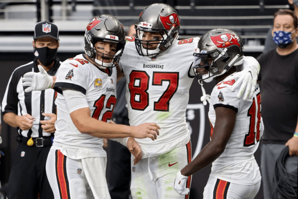 Tom Brady #12, Rob Gronkowski #87, and Tyler Johnson #18 of the Tampa Bay Buccaneers celebrate after scoring a touchdown in the second quarter against the Las Vegas Raiders at Allegiant Stadium on October 25, 2020 in Las Vegas, Nevada.