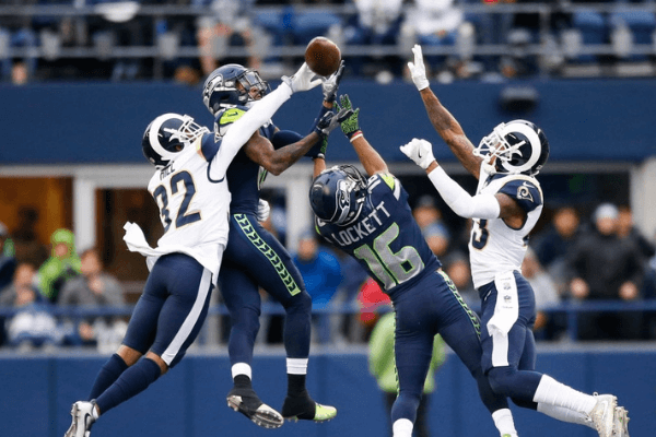 Cornerback Troy Hill #32 of the Los Angeles Rams knocks away a pass as wide receiver Paul Richardson #10 of the Seattle Seahawks and Tyler Lockett #16 try to make the completion during the 2nd quarter of the game at CenturyLink Field on December 17, 2017 in Seattle, Washington.