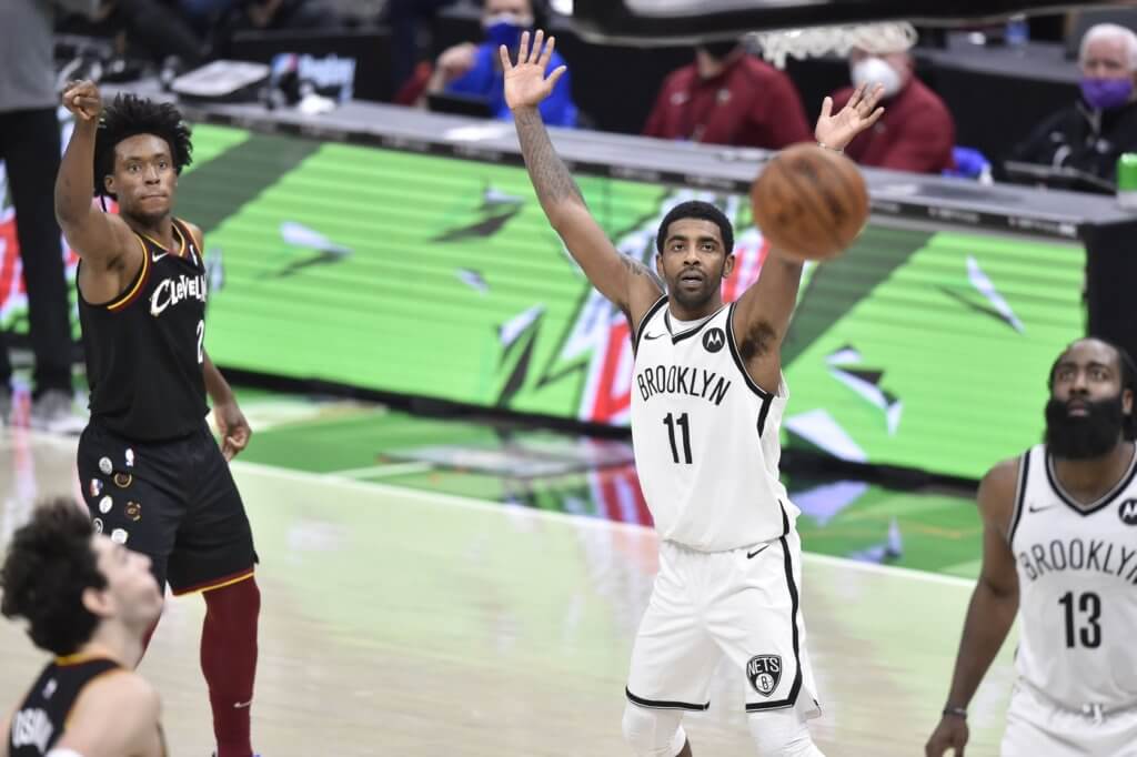 Jan 20, 2021; Cleveland, Ohio, USA; Brooklyn Nets guard Kyrie Irving (11) and guard James Harden (13) watch as Cleveland Cavaliers guard Collin Sexton (2) makes a three-point basket at the end of the first overtime at Rocket Mortgage FieldHouse. Mandatory Credit: David Richard-USA TODAY Sports