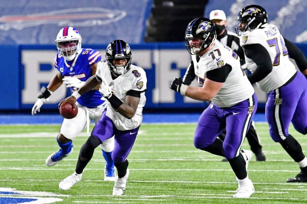 Baltimore Ravens quarterback Lamar Jackson (8) runs with the ball against the Baltimore Ravens during the second half of an AFC Divisional Round playoff game at Bills Stadium.