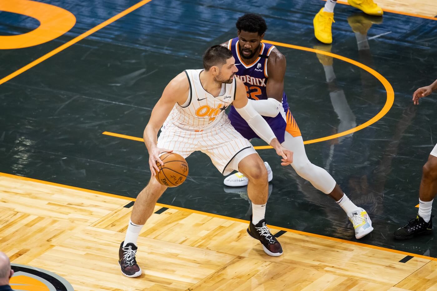 Mar 24, 2021; Orlando, Florida, USA; Orlando Magic center Nikola Vucevic (9) drives past Phoenix Suns center Deandre Ayton (22) during the fourth quarter of a game at Amway Center.