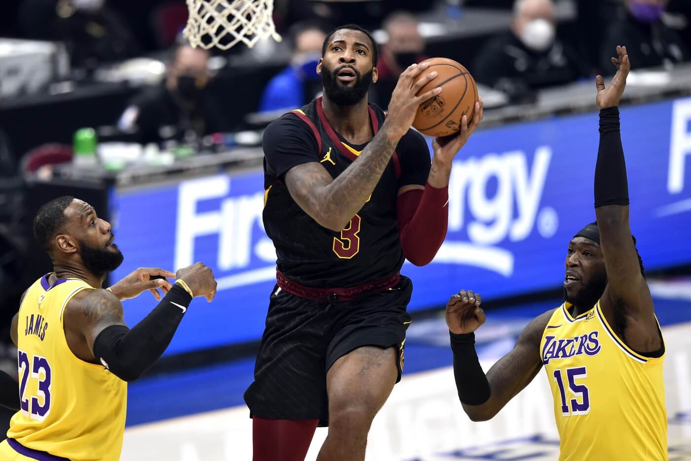 Jan 25, 2021; Cleveland, Ohio, USA; Cleveland Cavaliers center Andre Drummond (3) drives between Los Angeles Lakers forward LeBron James (23) and center Montrezl Harrell (15) in the first quarter at Rocket Mortgage FieldHouse. Mandatory Credit: David Richard-USA TODAY Sports