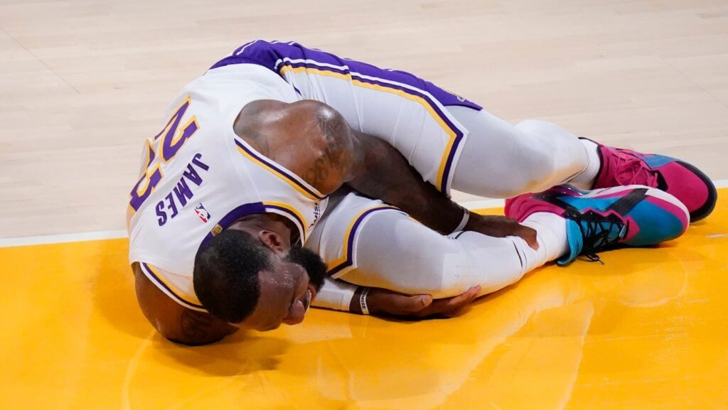 Mar 20, 2021; Los Angeles, California, USA; Los Angeles Lakers forward LeBron James (23) grabs his leg after a collision with an Atlanta Hawks player in the second quarter at Staples Center. Mandatory Credit: Robert Hanashiro-USA TODAY Sports