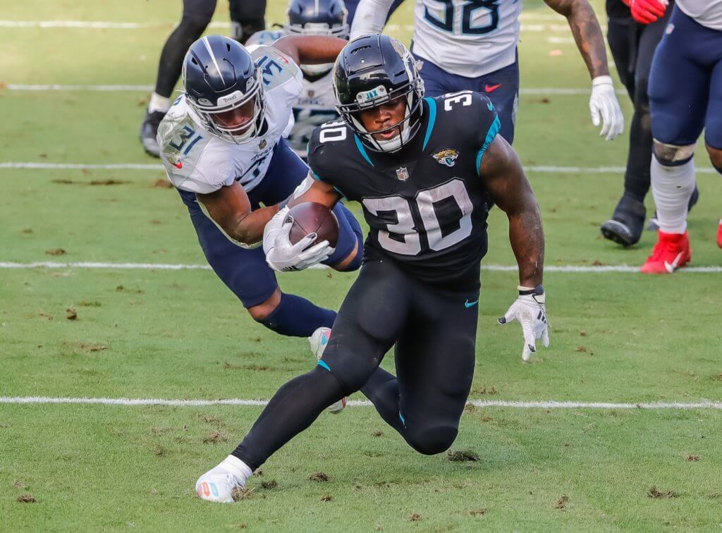 Dec 13, 2020; Jacksonville, Florida, USA; Jacksonville Jaguars running back James Robinson (30) carries the ball past Tennessee Titans free safety Kevin Byard (31) during the second half at TIAA Bank Field. Mandatory Credit: Mike Watters-USA TODAY Sports