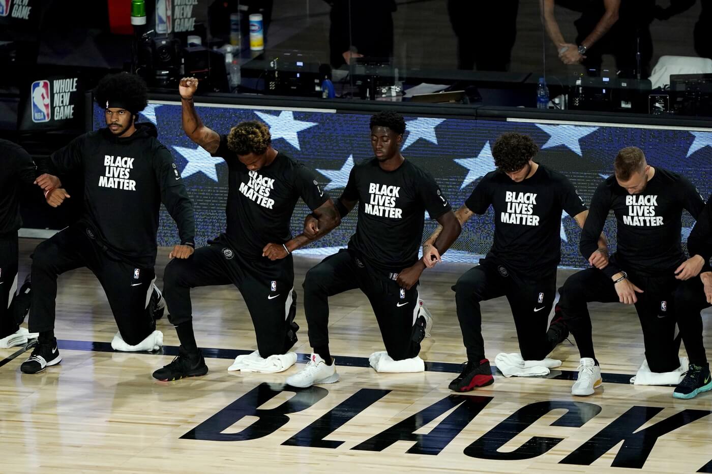 ooklyn Nets Lance Thomas, second from left, gestures as he and teammates kneel in honor of the Black Lives Matter movement prior to an NBA basketball game against the Portland Trail Blazers at ESPN Wide World of Sports Complex.