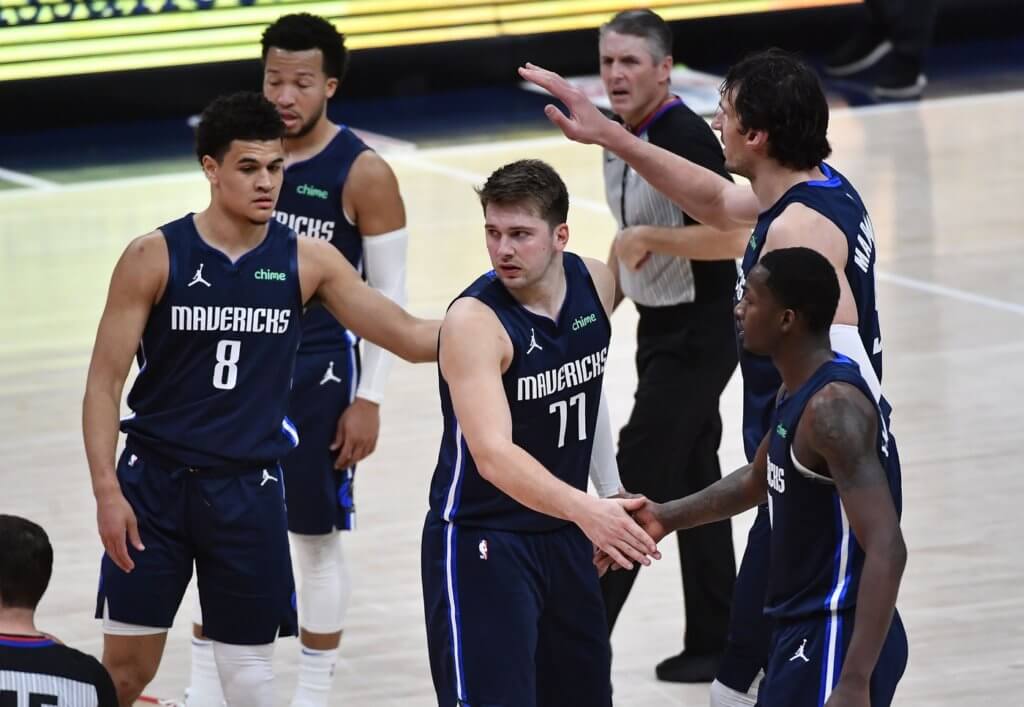 Apr 3, 2021; Washington, District of Columbia, USA; Dallas Mavericks guard Luka Doncic (77) is congratulated by teammates during the fourth quarter against the Washington Wizards at Capital One Arena. Mandatory Credit: Brad Mills-USA TODAY Sports