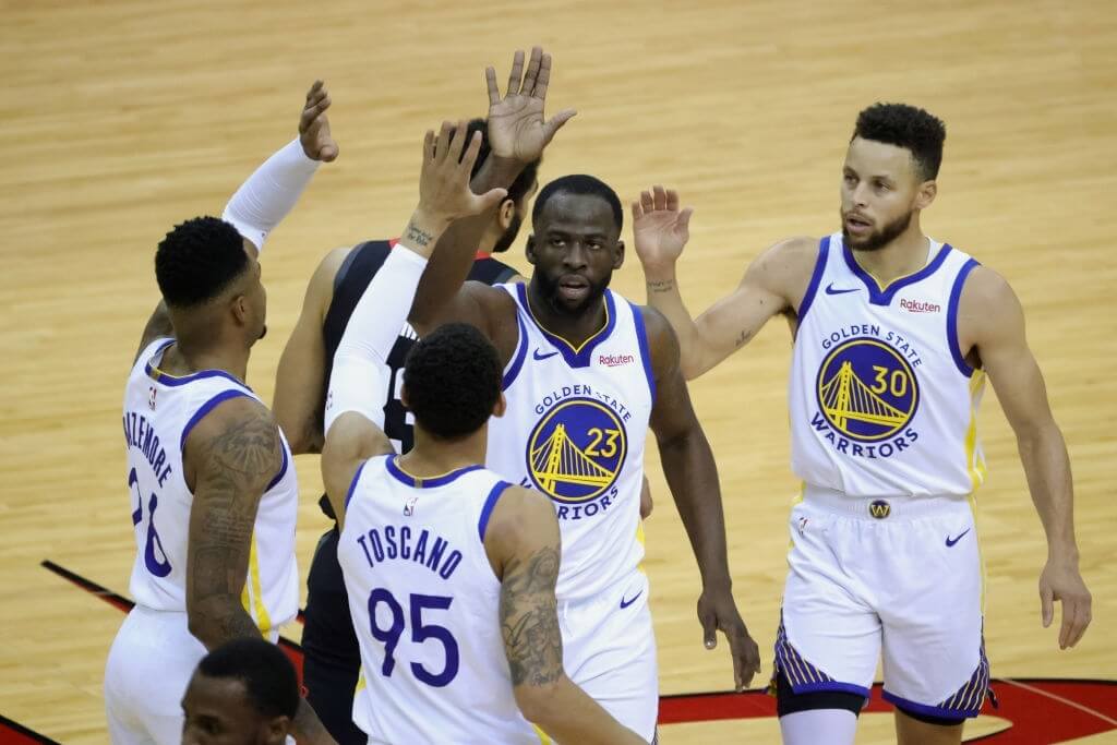 HOUSTON, TEXAS - MARCH 17: Draymond Green #23 of the Golden State Warriors high fives Kent Bazemore #26, Stephen Curry #30 and Juan Toscano-Anderson #95, during the first quarter of a game against the Houston Rockets at the Toyota Center on March 17, 2021 in Houston, Texas. NOTE TO USER: User expressly acknowledges and agrees that, by downloading and or using this photograph, User is consenting to the terms and conditions of the Getty Images License Agreement. (Photo by Carmen Mandato/Getty Images)