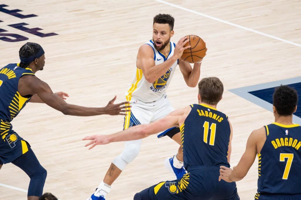 Feb 24, 2021; Indianapolis, Indiana, USA; Golden State Warriors guard Stephen Curry (30) looks to pass the ball away from the Indiana Pacers defense in the fourth quarter at Bankers Life Fieldhouse. Mandatory Credit: Trevor Ruszkowski-USA TODAY Sports