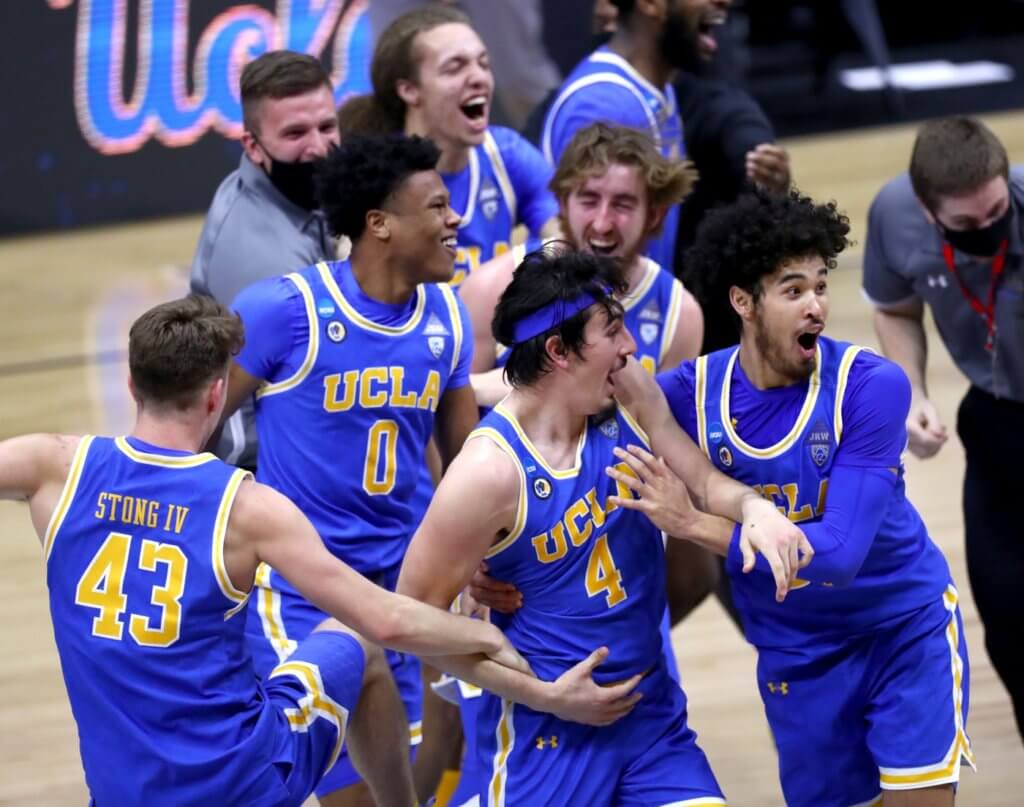 UCLA players celebrate after defeating Michigan during the Elite Eight round of the 2021 NCAA Tournament on Wednesday, March 31, 2021, at Lucas Oil Stadium in Indianapolis, Ind. Ncaa Basketball Ncaa Tournament Michigan Vs Ucla