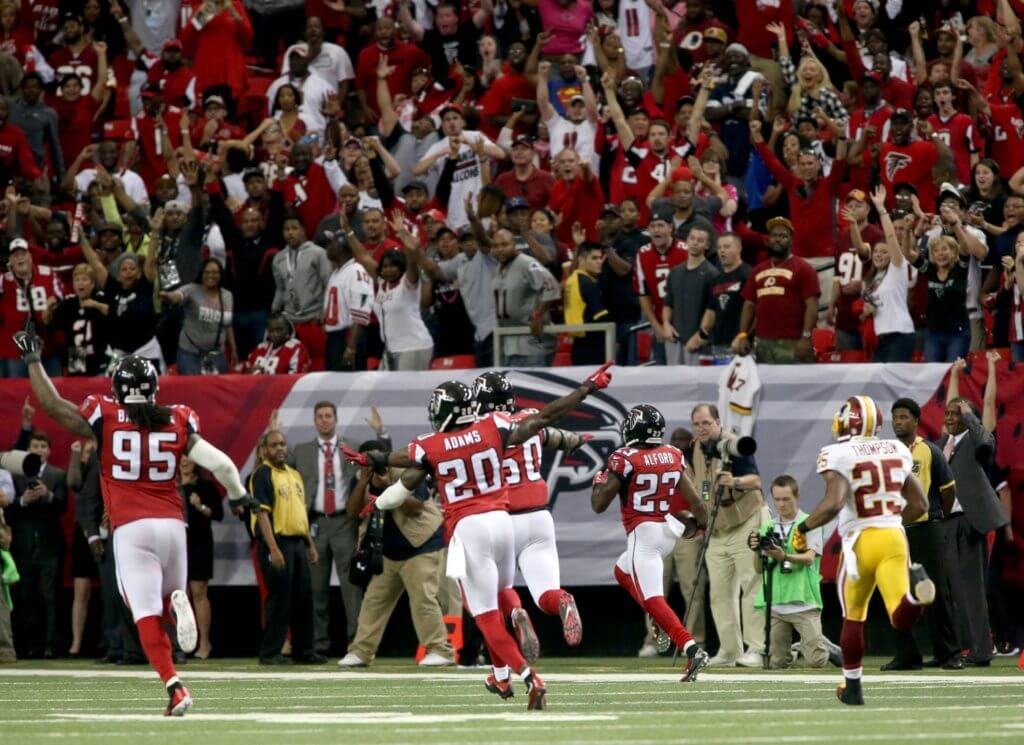 Oct 11, 2015; Atlanta, GA, USA; Atlanta Falcons defensive tackle Jonathan Babineaux (95) and defensive back Phillip Adams (20) celebrate as cornerback Robert Alford (23, right) returns an interception for a touchdown to win the game in overtime against the Washington Redskins at the Georgia Dome. The Falcons won 25-19 in overtime. Mandatory Credit: Jason Getz-USA TODAY Sports
