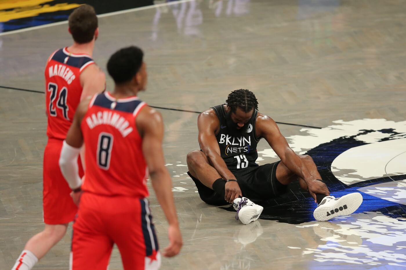 Mar 21, 2021; Brooklyn, New York, USA; Brooklyn Nets shooting guard James Harden (13) sits on the court after an injury at the end of the second quarter against the Washington Wizards at Barclays Center. Mandatory Credit: Brad Penner-USA TODAY Sports