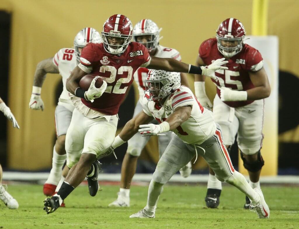Alabama Crimson Tide running back Najee Harris (22) breaks away from Ohio State linebacker Justin Hilliard (47) as he runs during the College Football Playoff National Championship Game in Hard Rock Stadium.