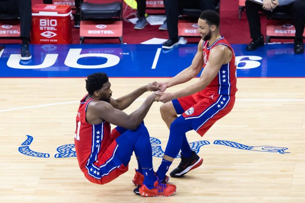 May 14, 2021; Philadelphia, Pennsylvania, USA; Philadelphia 76ers guard Ben Simmons (25) helps center Joel Embiid (21) up from the court floor during the second quarter against the Orlando Magic at Wells Fargo Center. Mandatory Credit: Bill Streicher-USA TODAY Sports