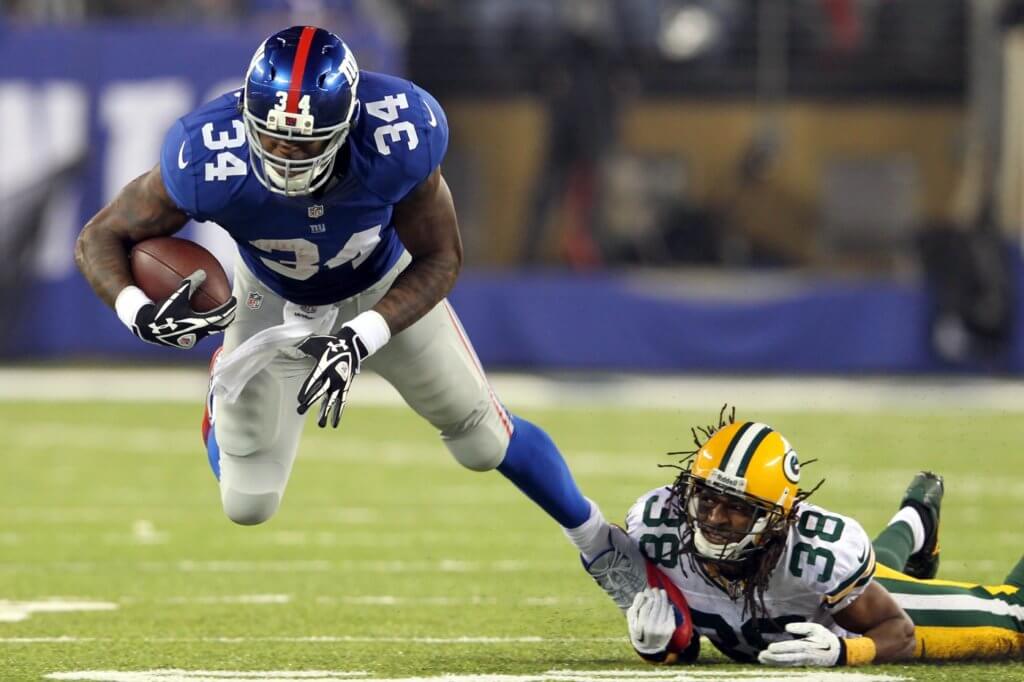 Nov 17, 2013; East Rutherford, NJ, USA; New York Giants running back Brandon Jacobs (34) is tackled by Green Bay Packers corner back Tramon Williams (38) during the first quarter of a game at MetLife Stadium. Mandatory Credit: Brad Penner-USA TODAY Sports

