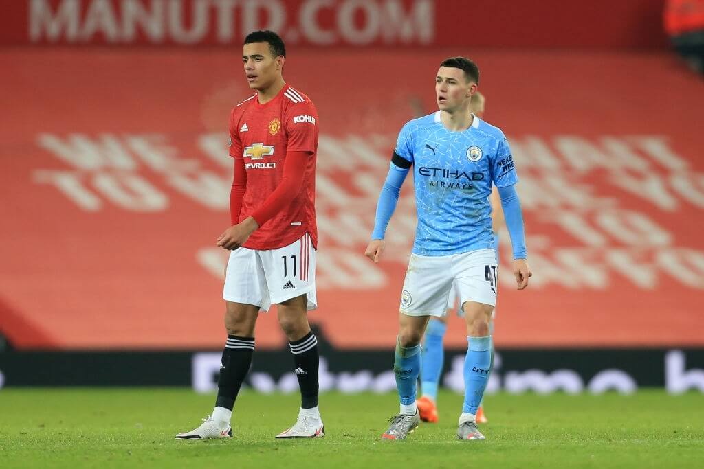 MANCHESTER, ENGLAND - JANUARY 06: Mason Greenwood of Man Utd and Phil Foden of Manchester City during the Carabao Cup Semi Final match between Manchester United and Manchester City at Old Trafford on January 6, 2021 in Manchester, England.