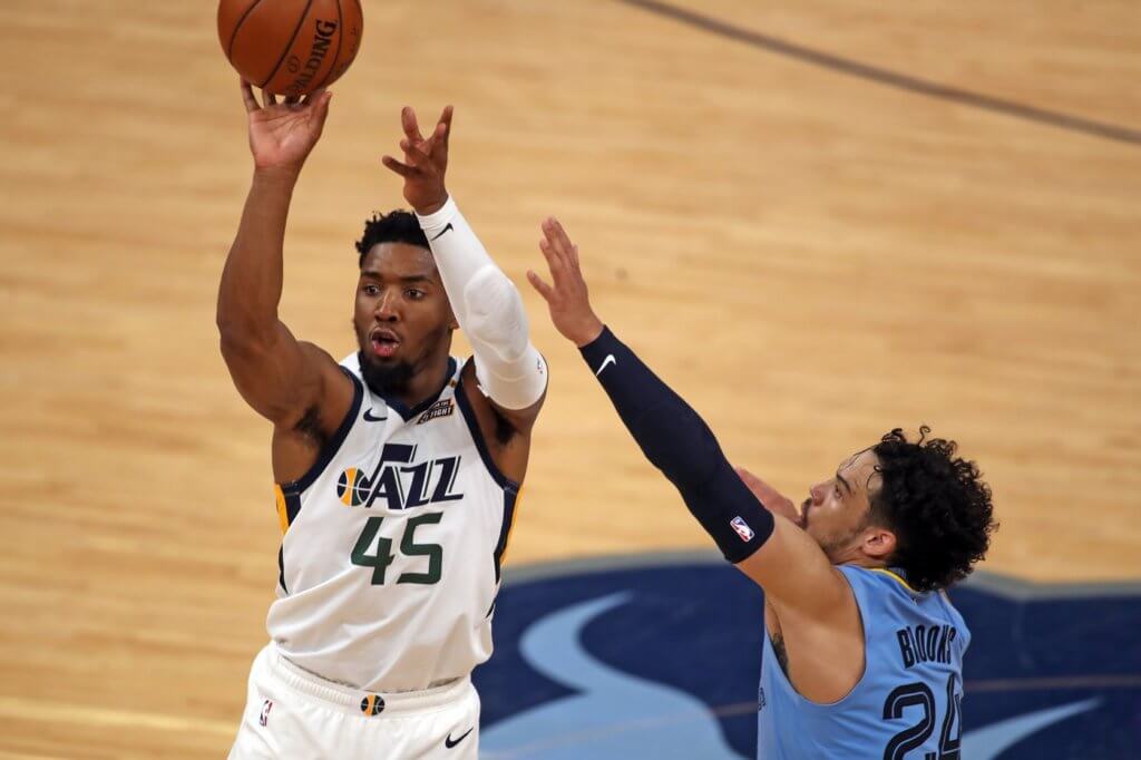 May 29, 2021; Memphis, Tennessee, USA; Utah Jazz guard Donovan Mitchell (45) shoots for three over Memphis Grizzlies forward Dillon Brooks (24) during the fourth quarter during game three in the first round of the 2021 NBA Playoffs at FedExForum. Mandatory Credit: Petre Thomas-USA TODAY Sports