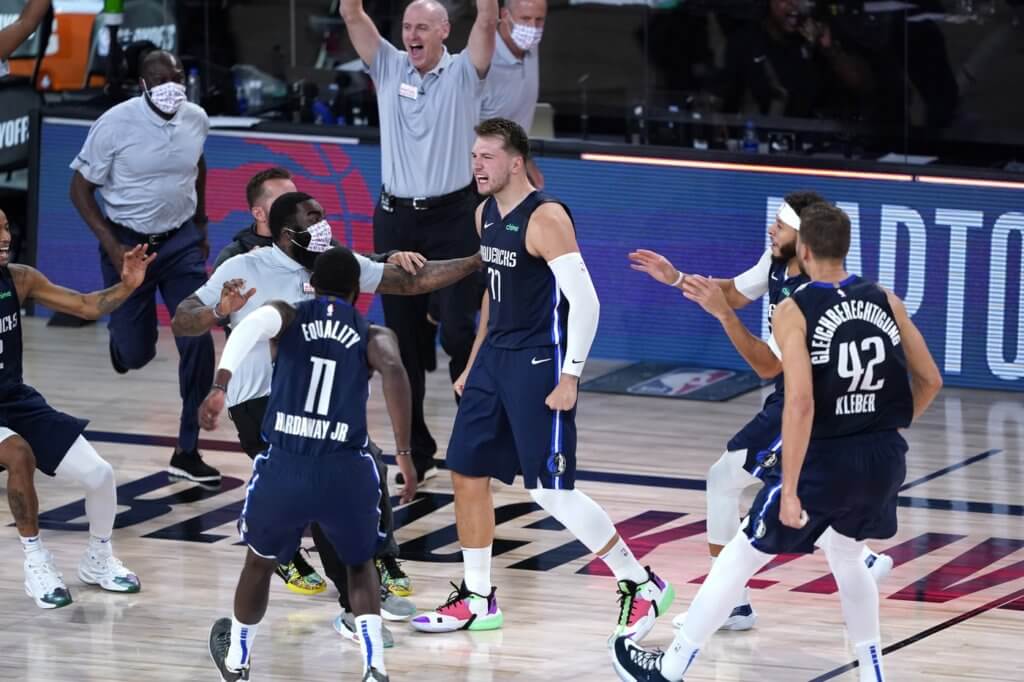 Aug 23, 2020; Lake Buena Vista, Florida, USA; Dallas Mavericks' Luka Doncic (77) celebrates with teammates after making a game-winning 3-point basket against the Los Angeles Clippers during overtime of an NBA basketball first round playoff game at AdventHealth Arena. Mandatory Credit: Ashley Landis/Pool Photo-USA TODAY Sports