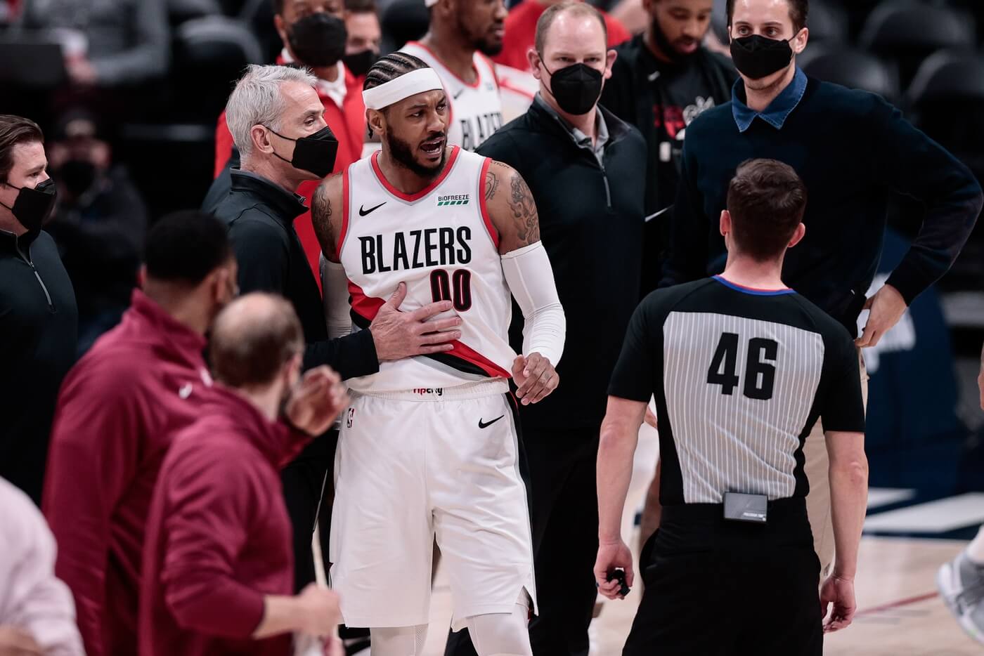 May 24, 2021; Denver, Colorado, USA; Portland Trail Blazers forward Carmelo Anthony (00) is held back by assistant coach John McCullough (L) as he argues a call with referee Ben Taylor (46) at the end of the second quarter against the Denver Nuggets during game two in the first round of the 2021 NBA Playoffs at Ball Arena.
