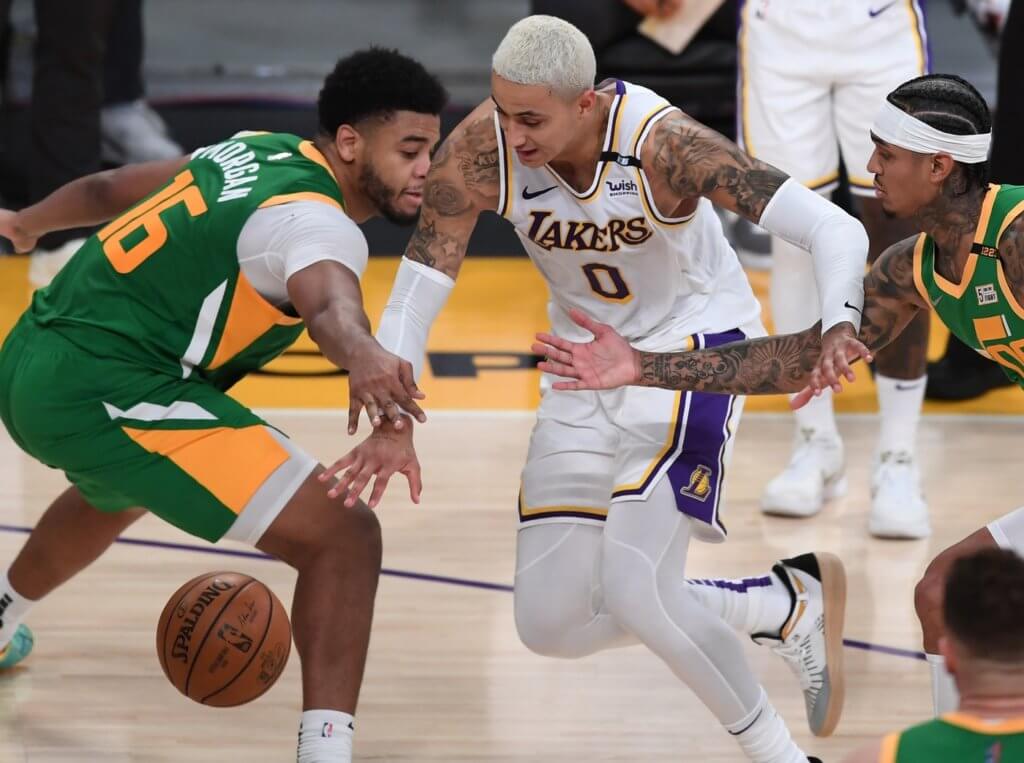 Apr 17, 2021; Los Angeles, California, USA; Utah Jazz forward Juwan Morgan (16) and guard Jordan Clarkson (00) defend Los Angeles Lakers forward Kyle Kuzma (0) as he drives to the basket in the second half of the game at Staples Center. Mandatory Credit: Jayne Kamin-Oncea-USA TODAY Sports