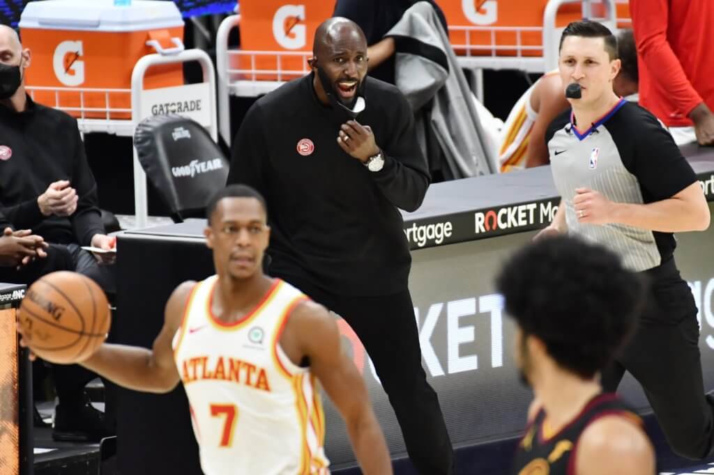 Feb 23, 2021; Cleveland, Ohio, USA; Atlanta Hawks head coach Lloyd Pierce yells to the team as guard Rajon Rondo (7) brings the ball up court during the third quarter against the Cleveland Cavaliers at Rocket Mortgage FieldHouse. Mandatory Credit: Ken Blaze-USA TODAY Sports

