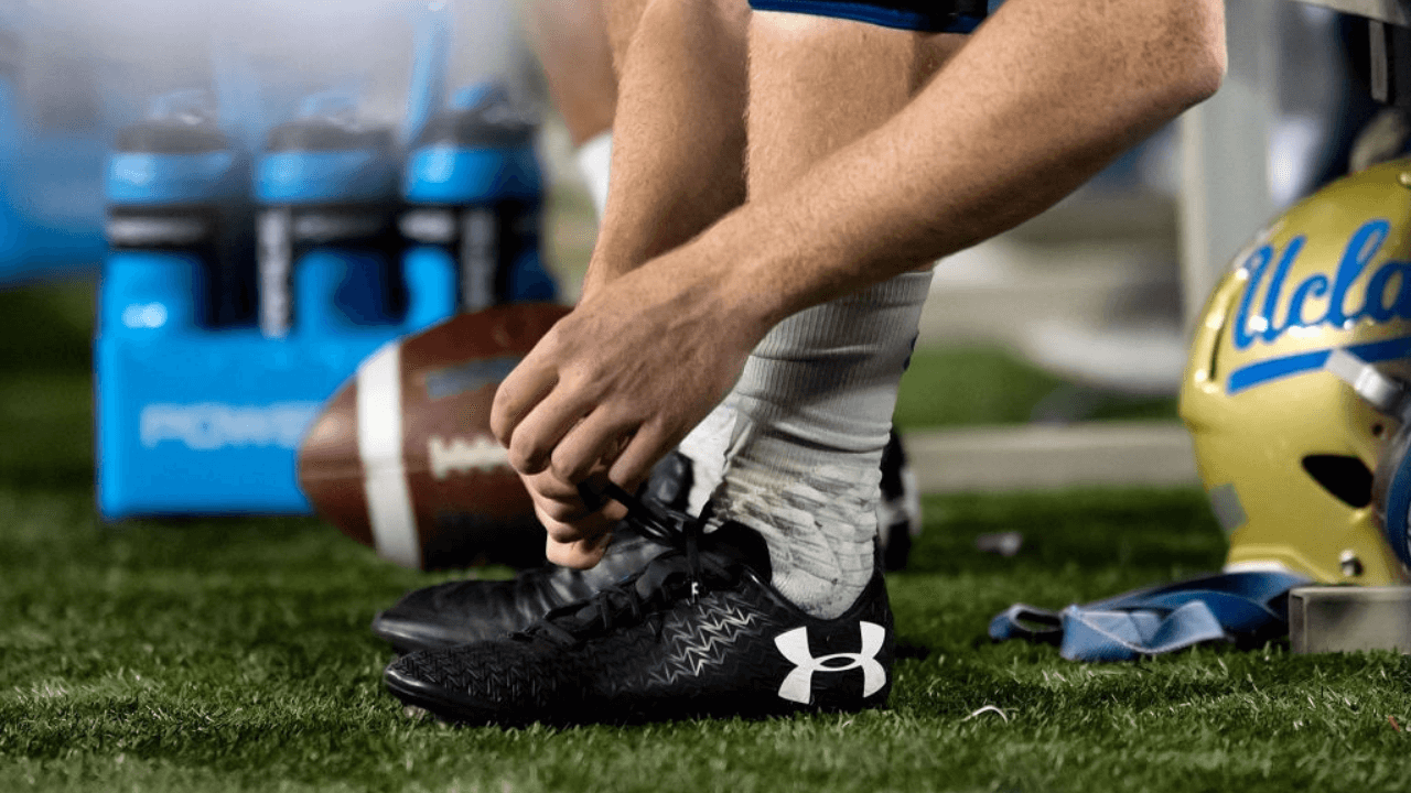 TUCSON, AZ - OCTOBER 14: A UCLA Bruins players adjusts his Under Armour cleats during the college football game between the UCLA Bruins and the Arizona Wildcats on October 14, 2017, at Arizona Stadium in Tucson, AZ. Arizona defeated UCLA 47-30. (Photo by Carlos Herrera/Icon Sportswire via Getty Images)
