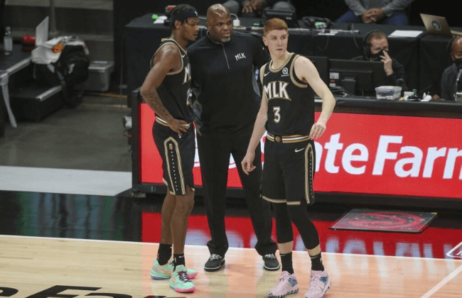 Jun 29, 2021; Atlanta, Georgia, USA; Atlanta Hawks head coach Nate McMillan talks to forward Cam Reddish (22) and guard Kevin Huerter (3) against the Milwaukee Bucks in the second quarter during game four of the Eastern Conference Finals for the 2021 NBA Playoffs at State Farm Arena. Mandatory Credit: Brett Davis-USA TODAY Sports