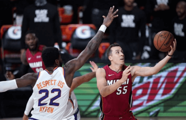 Aug 8, 2020; Lake Buena Vista, Florida, USA; Miami Heat's Duncan Robinson (55) goes to the basket as Phoenix Suns' Deandre Ayton (22) defends during the first half of an NBA basketball at Visa Athletic Center. Mandatory Credit: Ashley Landis/Pool Photo-USA TODAY Sports