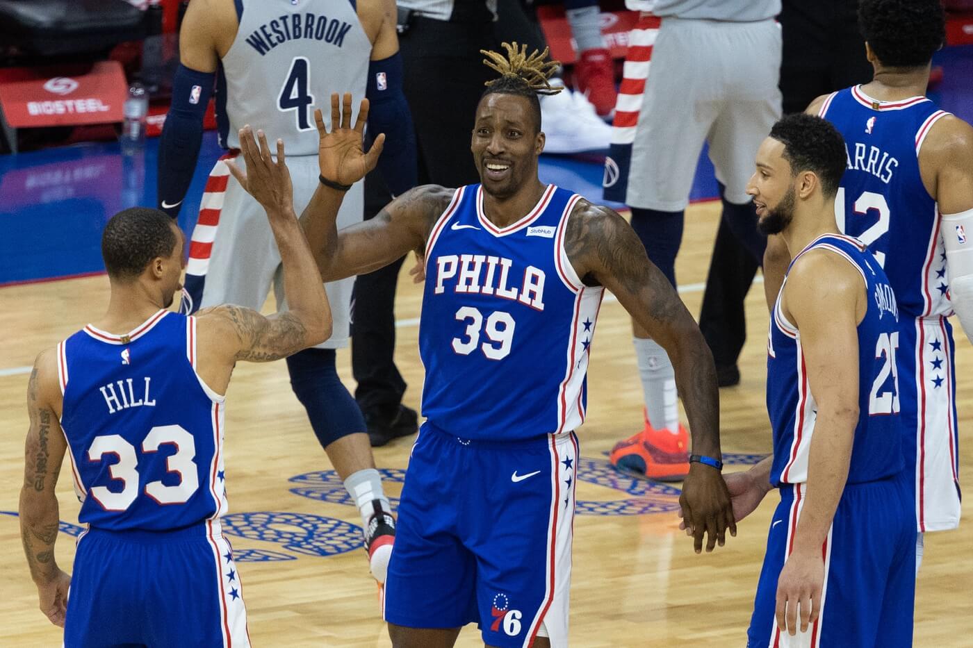 Jun 2, 2021; Philadelphia, Pennsylvania, USA; Philadelphia 76ers center Dwight Howard (39) celebrates with guards George Hill (33) and Ben Simmons (25) during the third quarter against the Washington Wizards in game five of the first round of the 2021 NBA Playoffs at Wells Fargo Center. Mandatory Credit: Bill Streicher-USA TODAY Sports