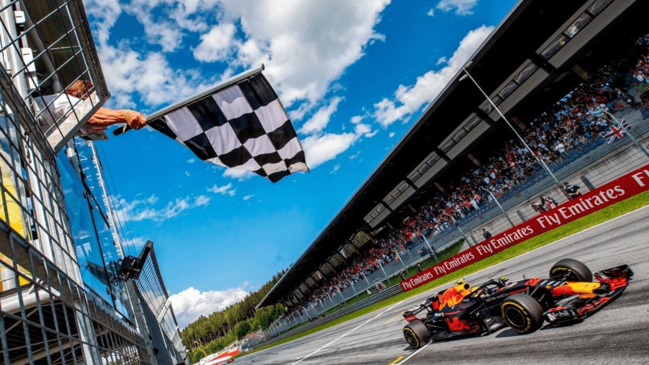 TOPSHOT - The flagman waves the chequered flag as Red Bull's Dutch driver Max Verstappen crosses the finish of the Austrian Formula One Grand Prix in Spielberg, central Austria, on July 1, 2018. (Photo by Srdjan SUKI / POOL / AFP) (Photo credit should read SRDJAN SUKI/AFP via Getty Images)