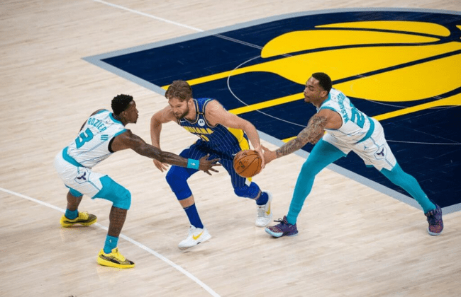 May 18, 2021; Indianapolis, Indiana, USA; Indiana Pacers forward Domantas Sabonis (11) dribbles the ball while Charlotte Hornets guard Terry Rozier (3) and forward P.J. Washington (25) defend in the first quarter at Bankers Life Fieldhouse. Mandatory Credit: Trevor Ruszkowski-USA TODAY Sports