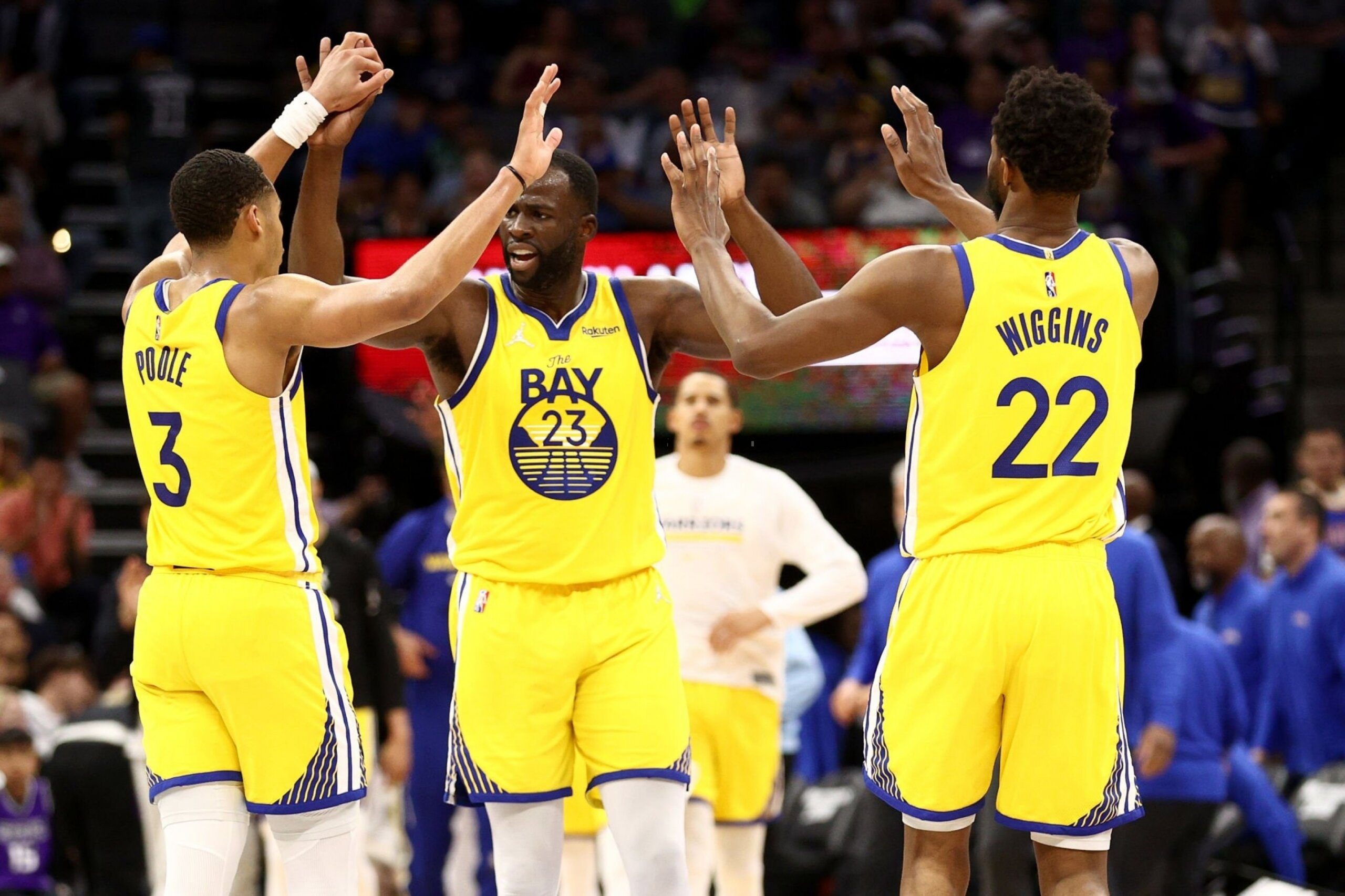 SACRAMENTO, CALIFORNIA - APRIL 03: Jordan Poole #3, Draymond Green #23 and Andrew Wiggins #22 of the Golden State Warriors high five after the Warriors scored a basket against the Sacramento Kings in the second half at Golden 1 Center on April 03, 2022 in Sacramento, California. Photo by Ezra Shaw/Getty Images