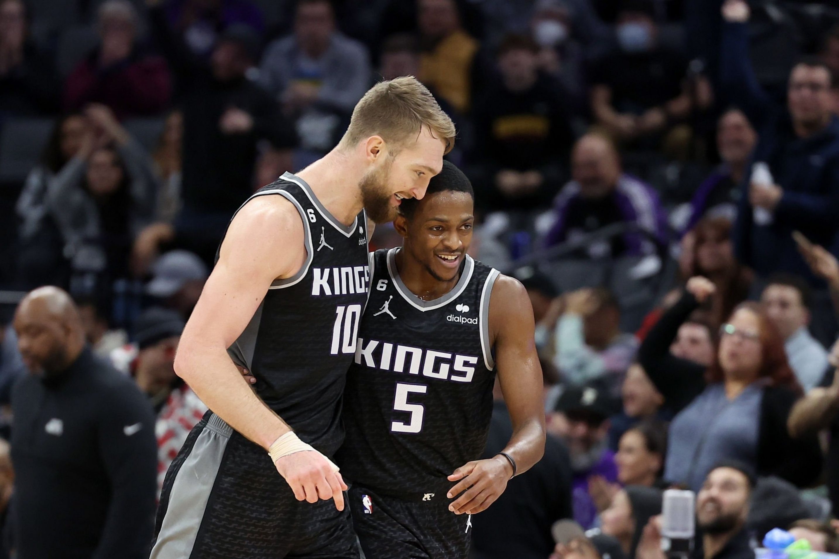 SACRAMENTO, CALIFORNIA - JANUARY 11: Domantas Sabonis #10 and De'Aaron Fox #5 of the Sacramento Kings react after Trey Lyles #41 made a three-point basket against the Houston Rockets in the second half at Golden 1 Center on January 11, 2023 in Sacramento, California.