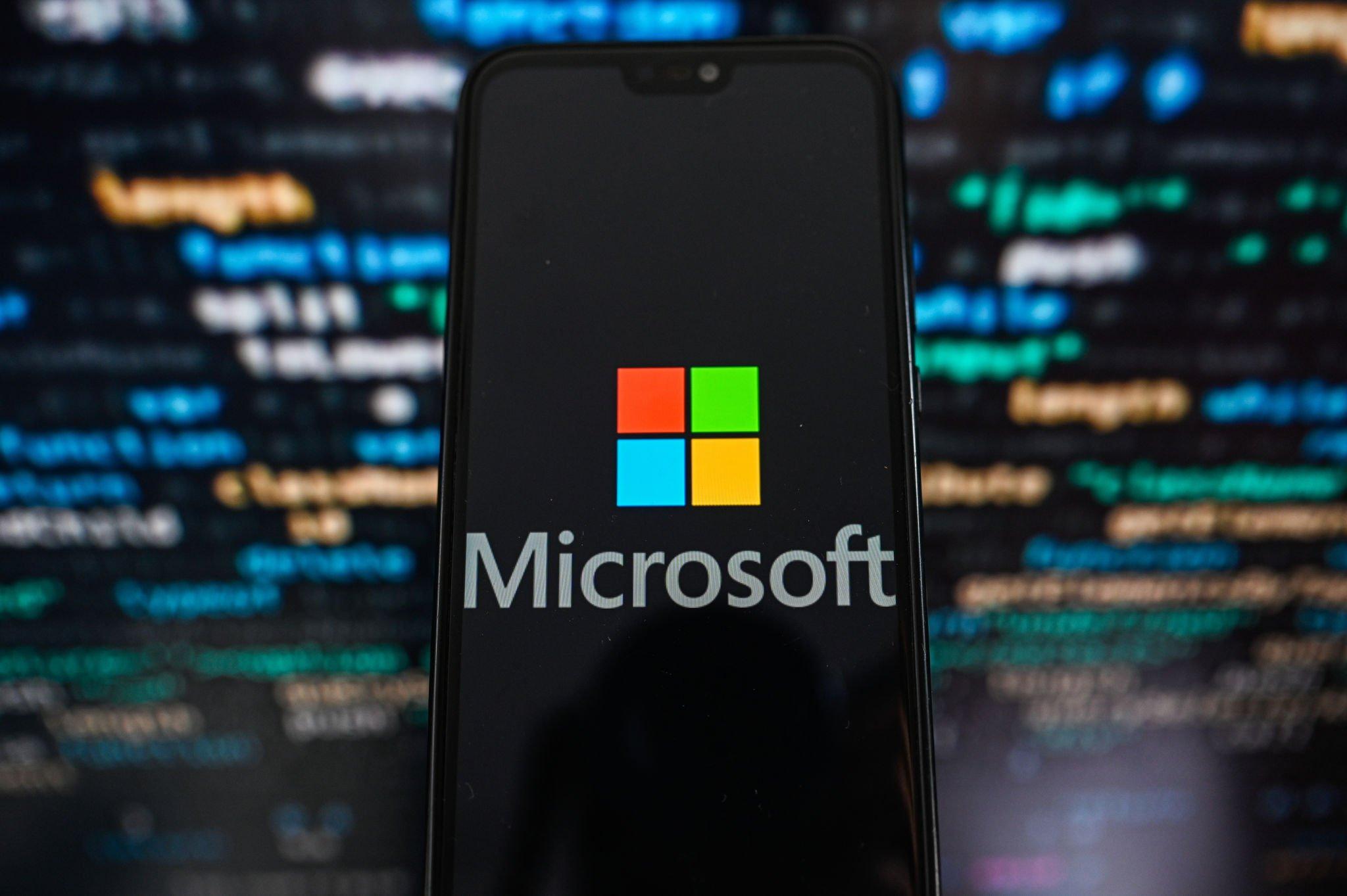 KRAKOW, POLAND - 2023/09/12: In this photo illustration a Microsoft logo displayed on a smartphone with programing code on the background. (Photo Illustration by Omar Marques/SOPA Images/LightRocket via Getty Images)