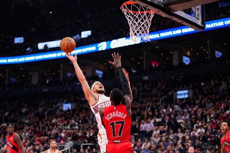 TORONTO, ON - NOVEMBER 29: Devin Booker #1 of the Phoenix Suns goes to the basket Agustin Dennis Schroder #17 of the Toronto Raptors during first half action at the Scotiabank Arena on November 29, 2023 in Toronto, Ontario, Canada. NOTE TO USER: User expressly acknowledges and agrees that, by downloading and/or using this Photograph, user is consenting to the terms and conditions of the Getty Images License Agreement. (Photo by Andrew Lahodynskyj/Getty Images)